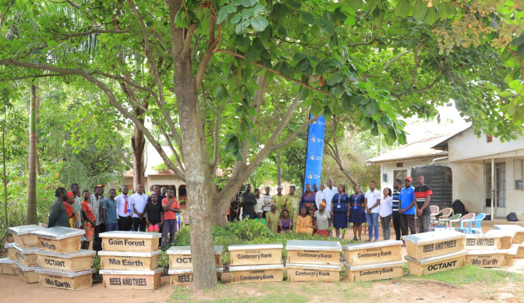 Group photo after training and handing over beehives, coffee and trees to youth and women.